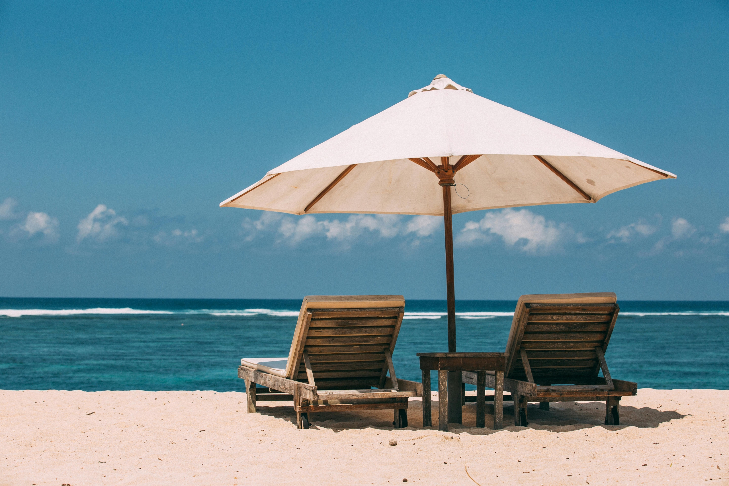 beach umbrella and chairs facing the ocean