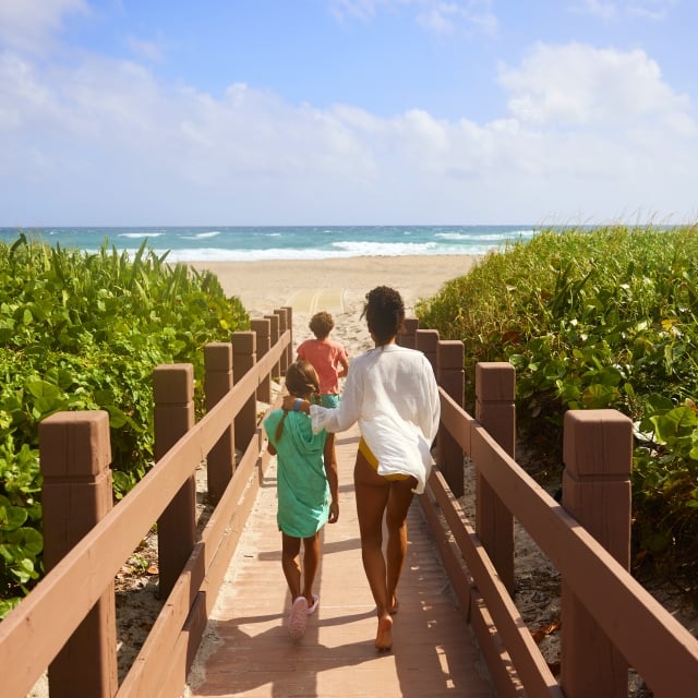 family walking towards the beach