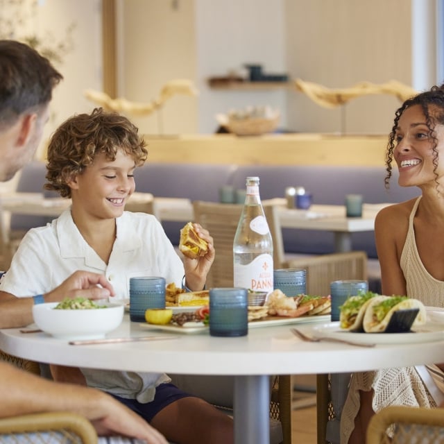 parents and two kids seated at table eating